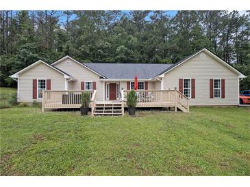 Charming single-story home featuring a spacious front yard and a welcoming wooden deck with access to the front door at 4746 Mulberry Rock Rd, Dallas, GA 30157