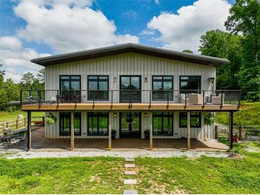 Striking two-story home featuring a spacious deck with modern railings, perfect for outdoor entertaining at 1971 Centennial Rd, Rutledge, GA 30663