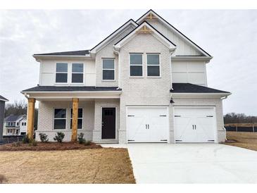 Charming two-story home with painted white brick, a two-car garage, and manicured front yard at 190 Orwell Dr, Social Circle, GA 30025