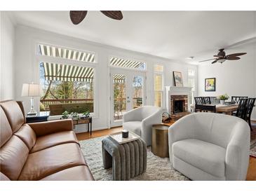 Bright living room featuring large windows, neutral colors, and a cozy fireplace perfect for relaxing at 220 Riverview Trl, Roswell, GA 30075