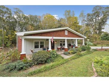 Charming craftsman style home with inviting front porch, beautiful landscaping and mature trees at 4442 Mclain Cir, Acworth, GA 30101