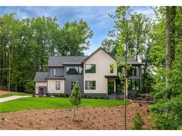 Beautiful new construction with three-car garage, board and batten siding, professional landscaping, and mature trees at 130 Nova Ln, Roswell, GA 30075