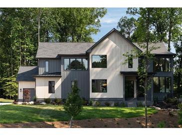 Modern two-story home with a combination of light and dark siding and well-maintained lawn at 130 Nova Ln, Roswell, GA 30075