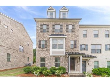 Charming brick townhome featuring a covered entryway, detailed trim, and well-maintained landscaping at 2252 Talmai Dr, Snellville, GA 30078
