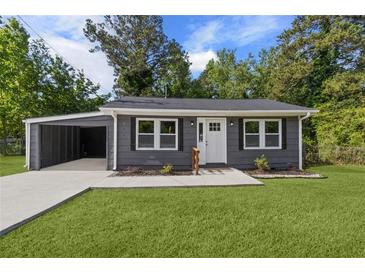 Charming gray home with a well-manicured lawn and a convenient carport at 389 Oglesby Bridge Se Rd, Conyers, GA 30094