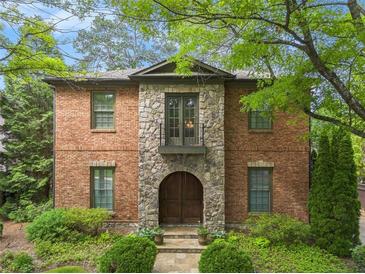 Charming brick home featuring a stone facade, arched doorway and second story balcony at 612 Concord Lake Se Cir, Smyrna, GA 30082
