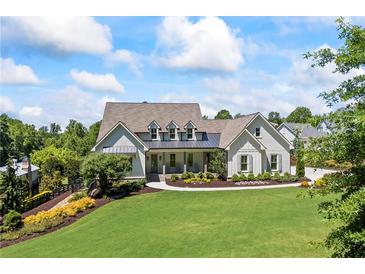 Beautiful single Gathering home with manicured front lawn and garden and charming white exterior at 115 Trinity Hollow Dr, Canton, GA 30115