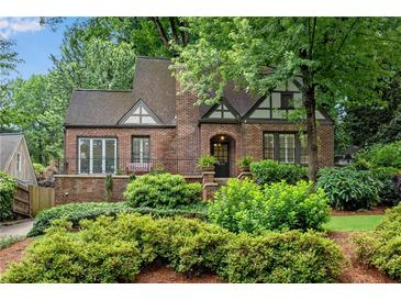 Charming brick home with Tudor accents, landscaped yard, and lush greenery at 1291 Stillwood Ne Dr, Atlanta, GA 30306