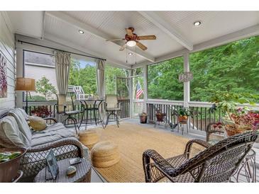 Cozy screened porch with wicker furniture, ceiling fan and views of the lush green backyard at 2073 Woodside Park Dr, Woodstock, GA 30188