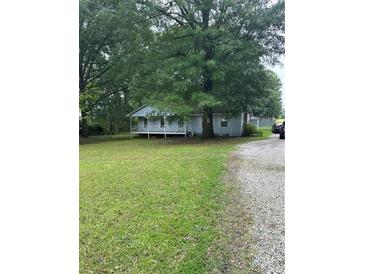 Quaint single-story home featuring a welcoming front porch and surrounded by mature trees and a spacious yard at 36 Mount Tabor Rd, Covington, GA 30014
