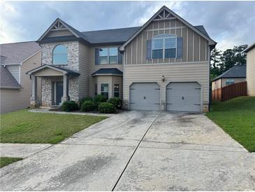 Traditional two-story home featuring a two-car garage and stone and siding exterior at 3897 Valley Bluff Ln, Snellville, GA 30039