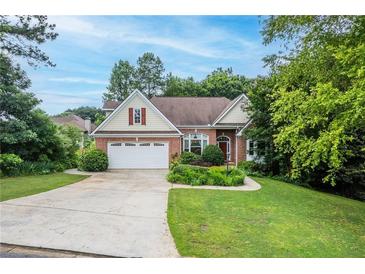 Charming brick home featuring a well-manicured lawn and a spacious two-car garage at 635 Piping Rock Pt, Lawrenceville, GA 30043