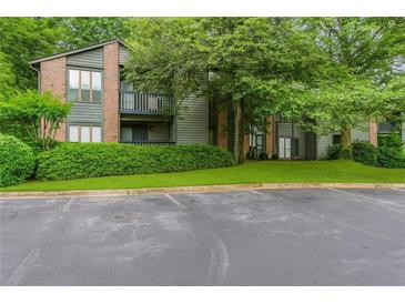 Condo with brick and siding, balcony, manicured lawn, and parking lot at 206 Tuxworth Cir, Decatur, GA 30033