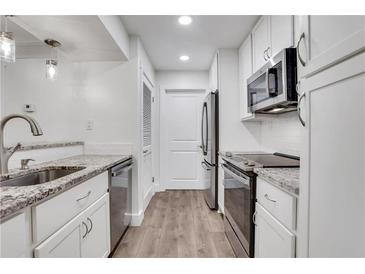 Bright kitchen features granite countertops, stainless steel appliances, and white cabinets at 206 Tuxworth Cir, Decatur, GA 30033