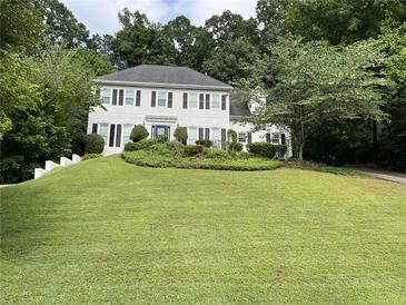 Charming two-story home featuring a manicured lawn, neutral paint, and dark shutters at 640 Belgrave Ln, Tucker, GA 30084