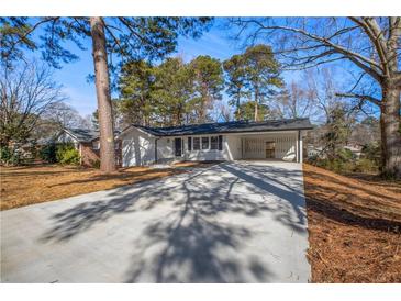 Charming renovated home with carport, white siding, dark shutters, and fresh landscaping at 1890 Carla Dr, Morrow, GA 30260
