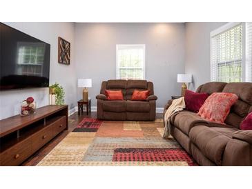 Inviting living room with brown couches, large windows, and a colorful area rug at 3479 Thompson Dr, Atlanta, GA 30331
