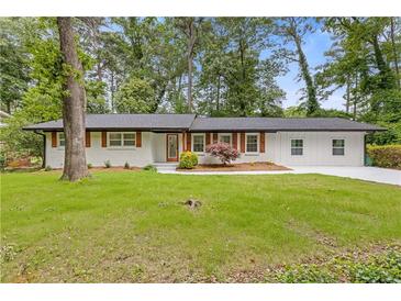 Charming renovated home featuring a manicured lawn, a neutral paint scheme, and complimentary shutters at 3614 N Druid Hills N Rd, Decatur, GA 30033