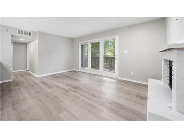 Bright living room featuring hardwood floors, fireplace and door to balcony with view at 113 Tuxworth Cir, Decatur, GA 30033