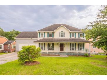 Charming two-story home with a large, inviting front porch and a well-maintained lawn at 5696 Glandor Dr, Mableton, GA 30126