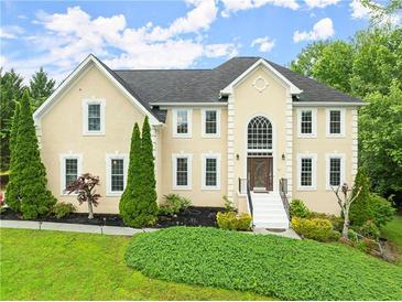 Charming two-story stucco home with a manicured lawn, mature trees, and inviting entrance at 789 Rutland Ct, Lithonia, GA 30058