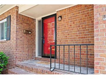 Inviting front porch featuring brick accents, a red door and black trim, providing a warm welcome to the residence at 3322 Northcrest Rd # A, Atlanta, GA 30340