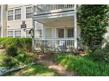 Inviting condo exterior featuring a covered porch, white railing, and lush landscaping, perfect for relaxing outdoors at 1364 Keys Crossing Ne Dr, Atlanta, GA 30319