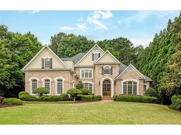 Elegant brick home with manicured lawn and lush landscaping, offering curb appeal at 314 Caruso Ct, Sandy Springs, GA 30350