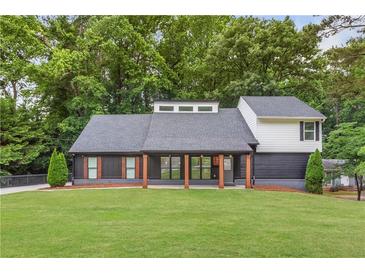 Charming home featuring a modern design with a covered porch and a well-manicured front yard at 347 Chip Rd, Stone Mountain, GA 30087