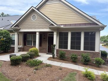Charming home with brick and siding, a well-manicured lawn and walkway leading to the front door at 1585 Oak Meadows Ln, Cumming, GA 30041