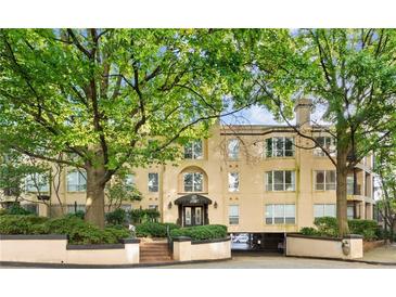 A tan three-story building featuring a brick entrance and trimmed by mature trees at 209 14Th Ne St # 109, Atlanta, GA 30309
