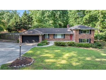 Charming brick home featuring a two-car garage and a lush, green front yard at 23 Hunting Creek Dr, Marietta, GA 30068
