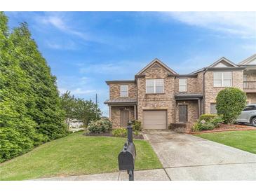 Charming brick townhome featuring a one-car garage, landscaped yard, and a classic architectural design at 2500 Morgan Chase Dr, Buford, GA 30519