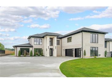 Stunning white brick home featuring a spacious driveway and lush green lawn at 2751 Camp Branch Rd, Buford, GA 30519