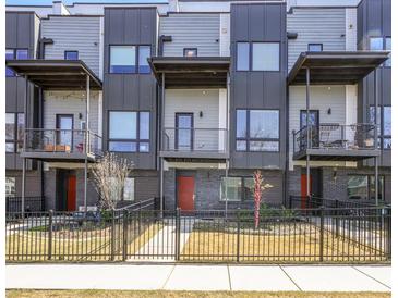 Modern townhouse featuring balconies, metal accents, and a well-maintained front yard with fence at 1145 Kirkwood Se Ave # 14, Atlanta, GA 30316