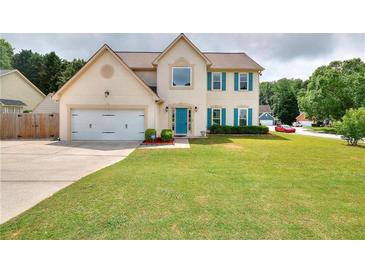 Charming two-story home featuring a lush green lawn and a lovely teal-blue front door and matching shutters at 2995 Belshire Trl, Dacula, GA 30019