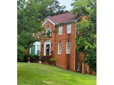 Charming brick two-story home with well-manicured lawn and mature landscaping at 6868 Wynbrooke Cv, Stone Mountain, GA 30087