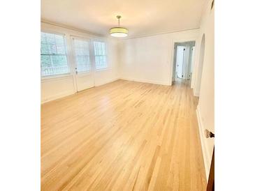 Bright living room featuring hardwood floors and neutral walls illuminated by stylish lighting at 2230 Peachtree Road Nw Rd # A4, Atlanta, GA 30309