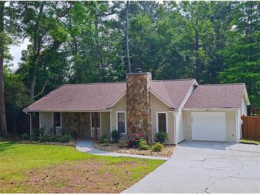 Charming ranch-style home featuring stone accents, a well-maintained lawn, and attached garage at 2405 Ingram Rd, Duluth, GA 30096