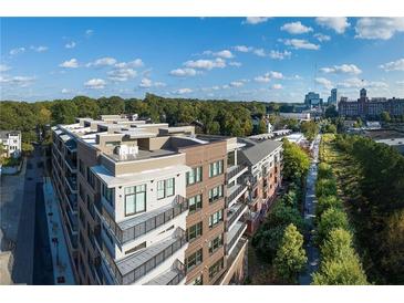 Modern apartment building boasts stunning architecture, complemented by a lush green landscape and clear blue skies at 675 Drewry Ne St # 205, Atlanta, GA 30306