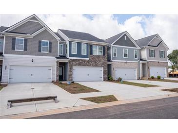 Attractive townhome exteriors showcasing modern architectural design and attached garages for convenient parking at 6011 Pine Bluff Pl, Conyers, GA 30013