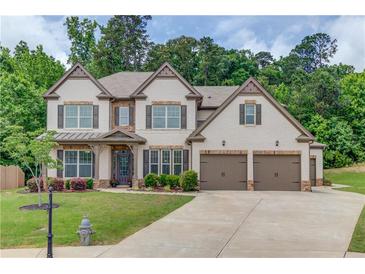 Charming two-story home boasts manicured landscaping, three-car garage and beautiful brick and siding exterior at 4241 Summer Breeze Way, Buford, GA 30518