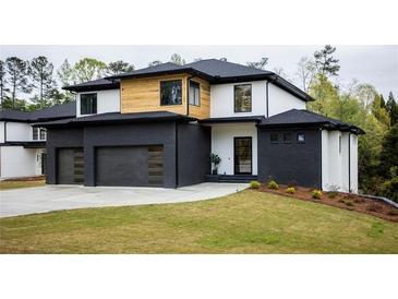 Modern two-story home with a black brick, white stucco, and natural wood exterior with a well-manicured lawn at 2551 Kilgore Rd, Buford, GA 30519