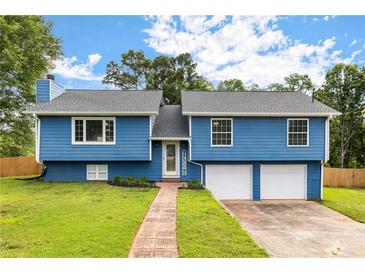 Charming blue two-story home with a well-manicured lawn and a brick pathway leading to the front door at 319 Hill Crest Cir, Woodstock, GA 30188