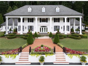 Stunning exterior elevation of a white home with black shutters and large column lined porch at 1822 Chartwell Trce, Stone Mountain, GA 30087