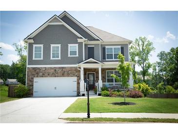Charming two-story home with a well-manicured lawn and a welcoming front porch at 4535 Sunflower Cir, Cumming, GA 30040