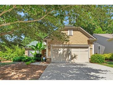 Charming single-Gathering home boasts a lush front yard and a two-car garage, complemented by mature trees and landscaping at 4535 Vanadium Bnd, Cumming, GA 30040