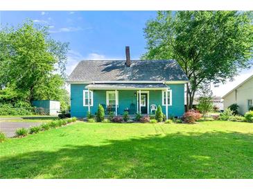 Charming blue home featuring a well-manicured lawn, lovely landscaping, and inviting front porch at 5150 Wheat Ne St, Covington, GA 30014