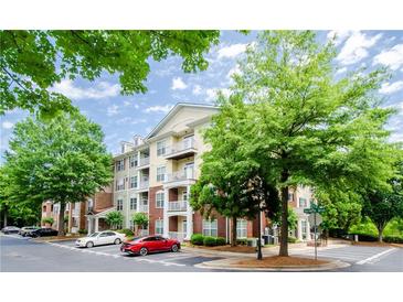 Condominium building with balconies, manicured landscaping, and parking at 1965 Nocturne Dr # 1306A, Alpharetta, GA 30009