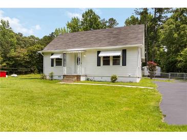 Charming home with a well-maintained lawn and classic architecture, blending comfort with curb appeal at 8185 Rivertown Rd, Fairburn, GA 30213